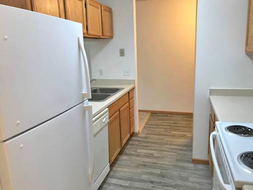 A kitchen with a white refrigerator and a white stove.