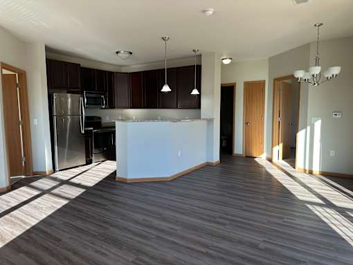 A kitchen with a refrigerator, oven, and microwave.