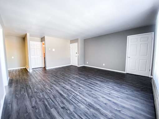 A room with a wooden floor and white walls.
