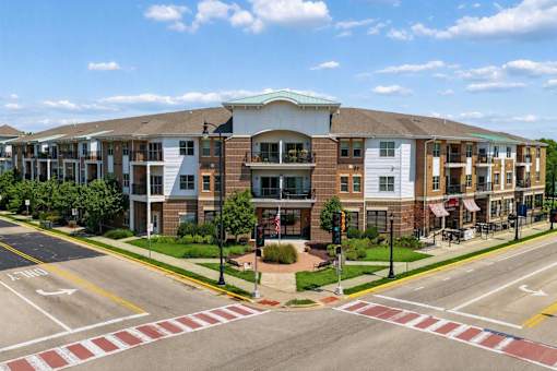 A street view of a residential area with apartment buildings and a pedestrian crossing.