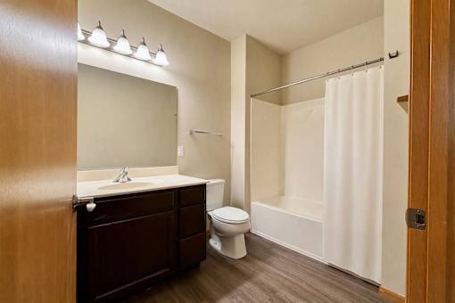 A bathroom with a toilet, sink, and shower.
