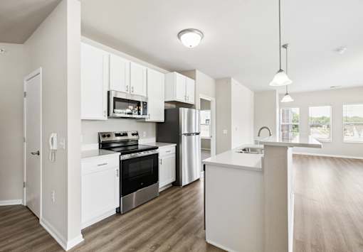 A modern kitchen with white cabinets and stainless steel appliances.