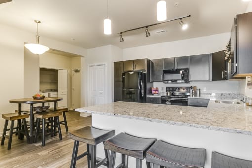 a kitchen with a large island with a breakfast bar and stools