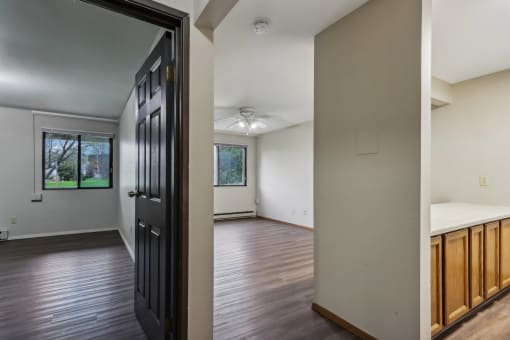 an empty living room with wooden floors and a black door