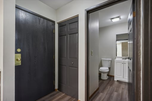 a bathroom with a toilet and a black door