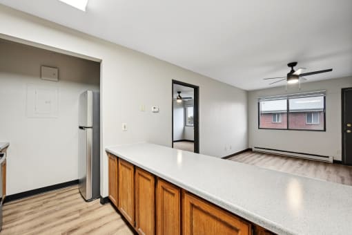 the kitchen and living room of an empty house with a refrigerator