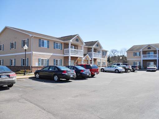 A parking lot with cars and apartment buildings in the background.