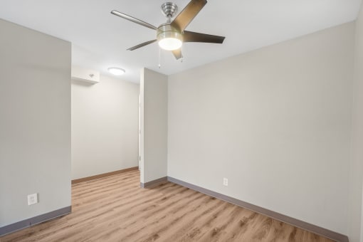the living room of an empty house with a ceiling fan