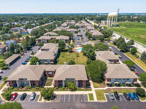 A water tower stands tall in the distance behind a cluster of houses.