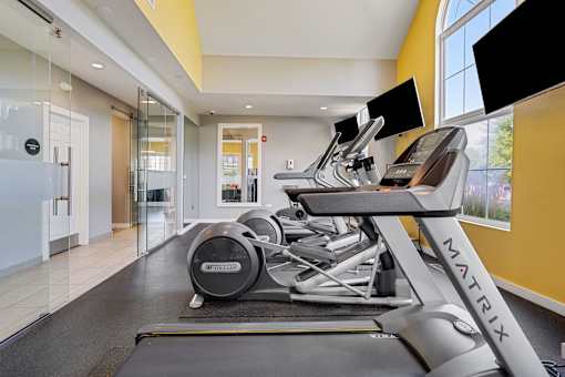 A gym with treadmills and a television.