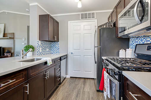 A kitchen with brown cabinets and a white door.