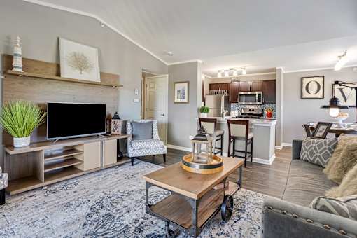 A living room with a grey couch and a wooden coffee table.