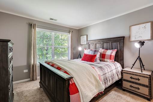 A bedroom with a large bed and a wooden dresser.