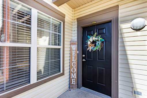 A black door with a wreath and a sign that says