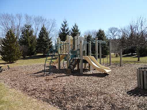 A playground with a slide and a climbing frame.