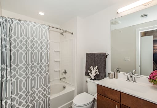 A bathroom with a white toilet, a white sink, and a shower curtain.