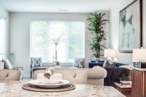 A dining table with a white plate and a napkin on it.