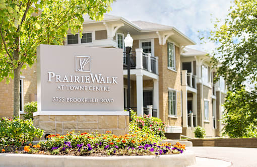 A sign for PrairieWalk at Towne Centre stands in front of a building.
