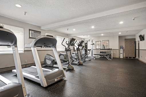 A spacious gym with treadmills, elliptical machines, and other exercise equipment.