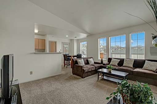 A living room with a brown couch and a flat screen TV.