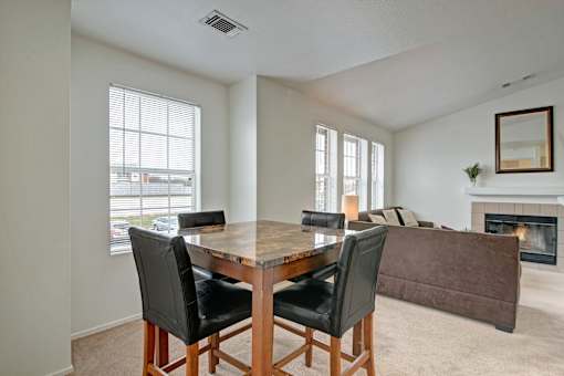 A dining room with a table and chairs.