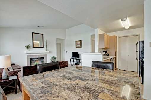 A living room with a fireplace and a large marble table.