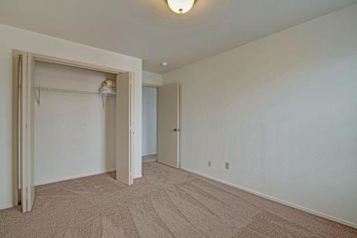 A room with a carpeted floor and a white door.