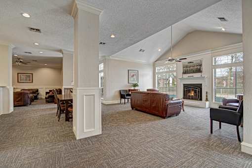 A large, well-lit living room with a fireplace and comfortable seating.