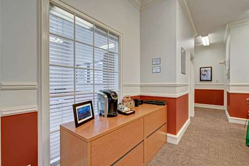 A room with a brown desk and a framed picture on it.