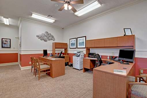 A room with two desks and chairs, one of which has a sign that says "Learning".