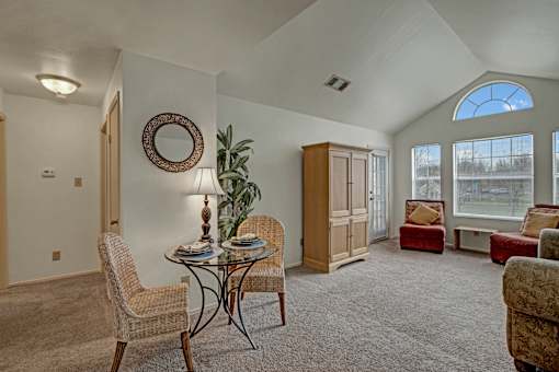 A living room with a glass table and chairs.
