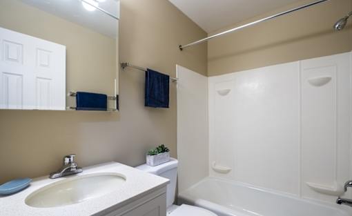 A bathroom with a white tub and sink.