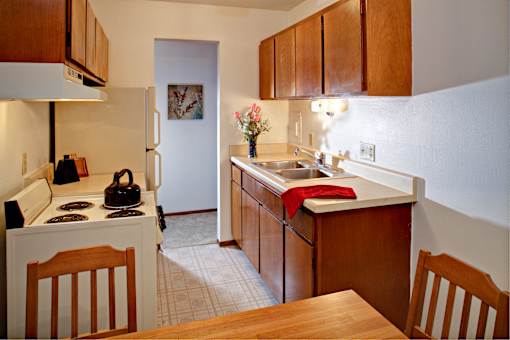 A kitchen with wooden cabinets and a white refrigerator.