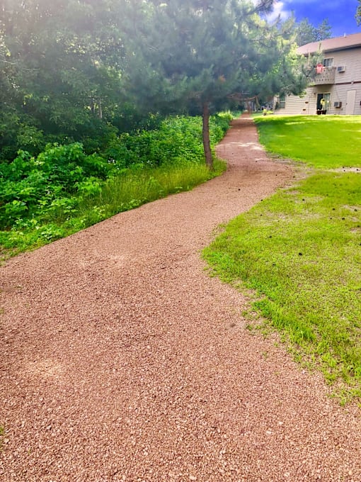 A dirt path winds through a grassy area.