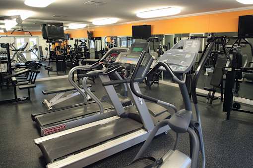 A gym with treadmills and other exercise equipment.