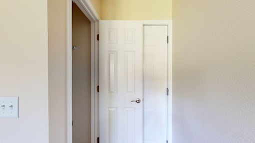 A white door is in a room with yellow walls.