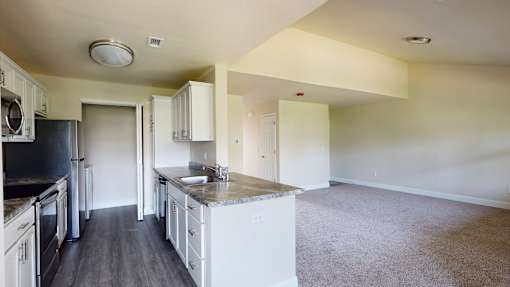 A kitchen with white cabinets and a black countertop.