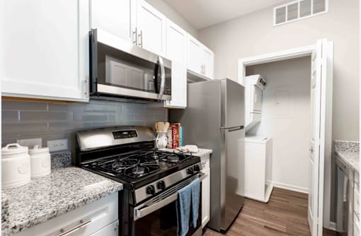 A kitchen with a black stove top oven and white cabinets.