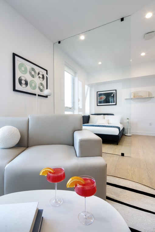 a living room with a couch and a table with two wine glasses