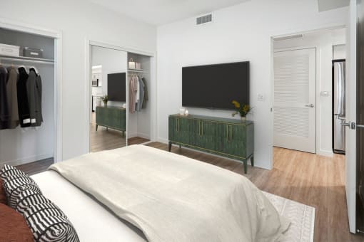 a bedroom with a bed and a television on the wall
