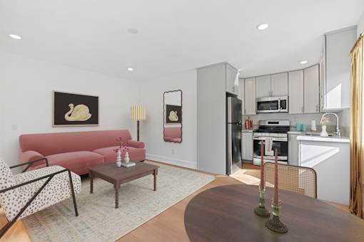 Spacious living room in Mar Vista apartment with open concept leading to modern kitchen and dining area. Large windows allow for gorgeous natural lighting and plank flooring