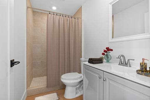 Bathroom in Mar Vista Apartment home with plank flooring, spacious shower, and modern vanity with plenty of cabinet storage.