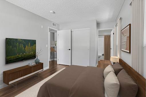 Spacious bedroom in 1 bed 1 bath Azusa Gardens apartment home with wood style plank flooring, multiple windows for natural lighting and views, and a private bathroom