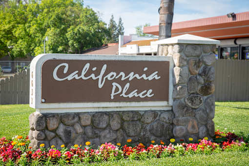 Stone monument sign at the entrance to California Place apartments