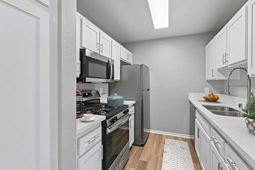 Updated kitchen in Azusa Gardens 2 bed 1 Bath apartment home with wood-style plank flooring, white shaker cabinets, quartz countertops, stainless appliances and brushed nickel finishes.