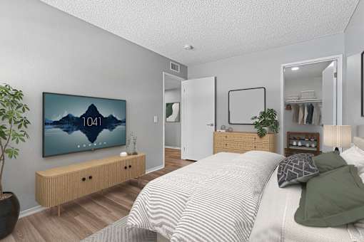 Spacious primary bedroom in The Park 2-bedroom unit with plank flooring, oversized closet and private bathroom.