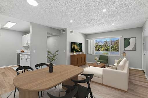 View of living room and kitchen from dining nook in Azusa Gardens 2 bed 1 bath apartment home with wood style plank flooring, and view of large windows in the living area which allow gorgeous natural lighting to filter throughout the space.