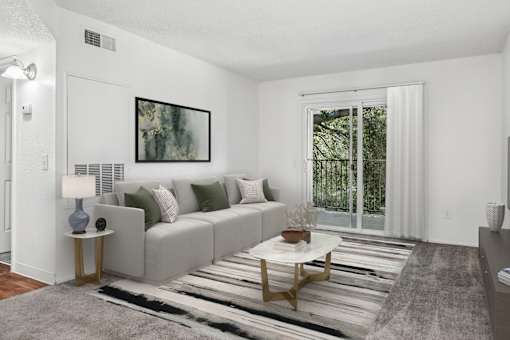 Living Room in 2 Bed 1 bath bent tree apartment home with carpeted flooring, and sliding doors leading to private patio/balcony. Sliding doors allow for gorgeous natural lighting to fill the space.