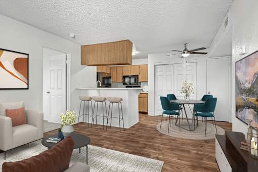 Living Room in 2 Bed 2 Bath Bent Tree Apartment with Large Windows allowing for gorgeous natural lighting, wood plank-style flooring, and view into dining nook & kitchen complete with bar top seating