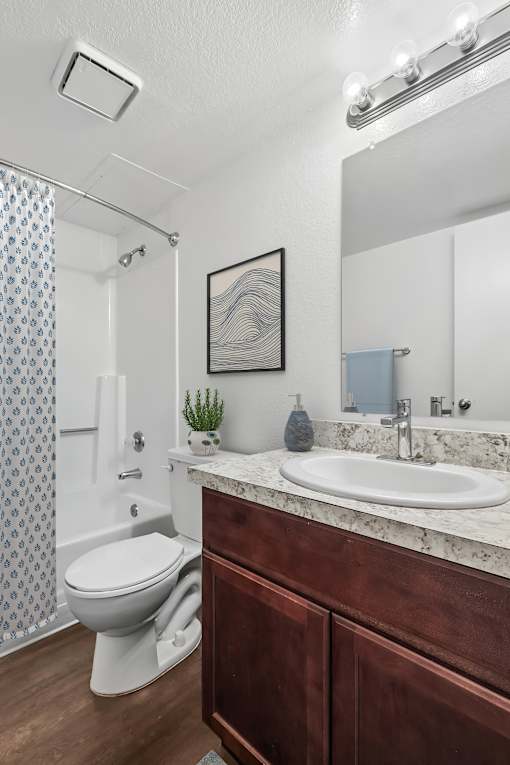Bathroom in 1 Bed 1 Bath Bent Tree Apartment with wood-style plank flooring, plenty of cabinet space, a large vanity mirror, and a shower/tub